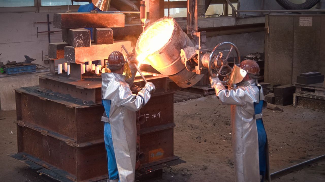 [Translate to Englisch:] Foundry worker casting steel on particularly large sand mold 