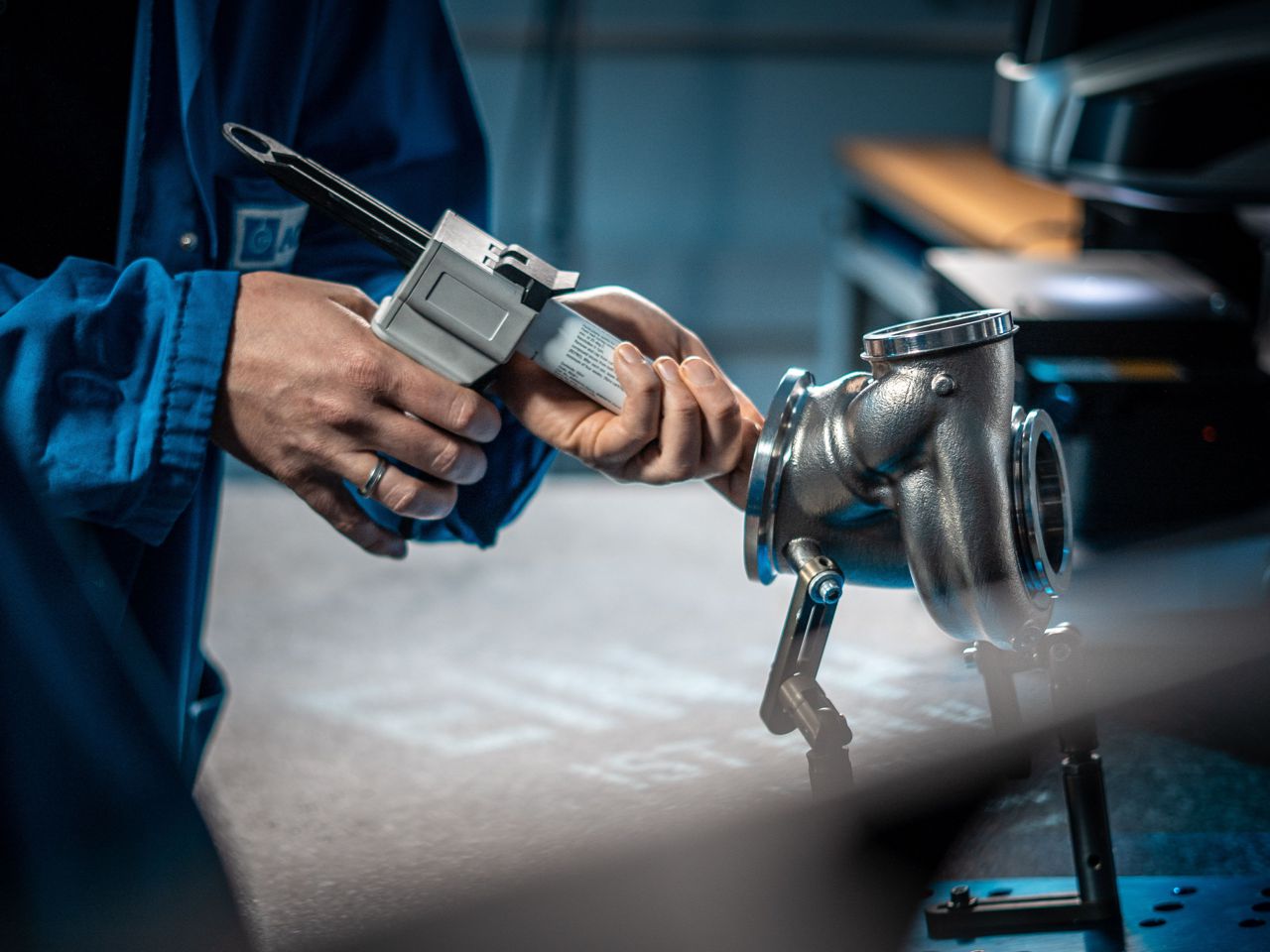 [Translate to Englisch:] an employee injects a silicone compound into a turbocharger
